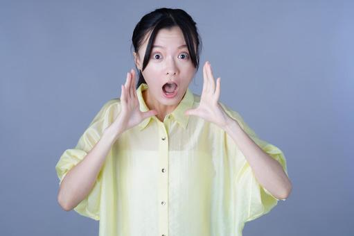 びっくりした顔の黄色い服の女性 女性,びっくり,叫ぶの写真素材