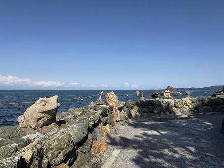 かえるの先に広がる海と夫婦岩 かえるの先に広がる海と夫婦岩 かえる,石像,海の写真素材