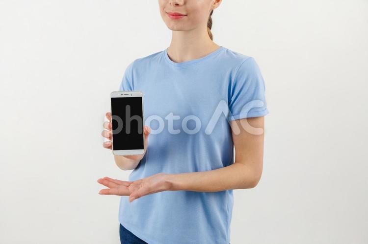 スマホ画面を見せる半袖の人の手元 スマートフォン,持つ,手元の写真素材