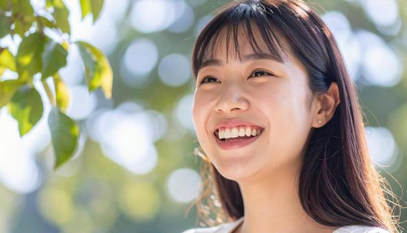 緑豊かな自然の中で笑顔の若い日本人女性 緑豊かな自然の中で笑顔の若い日本人女性の写真