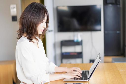 在宅勤務をする若いビジネスウーマン 在宅勤務をする若いビジネスウーマン 副業,非対面,チェックの写真素材