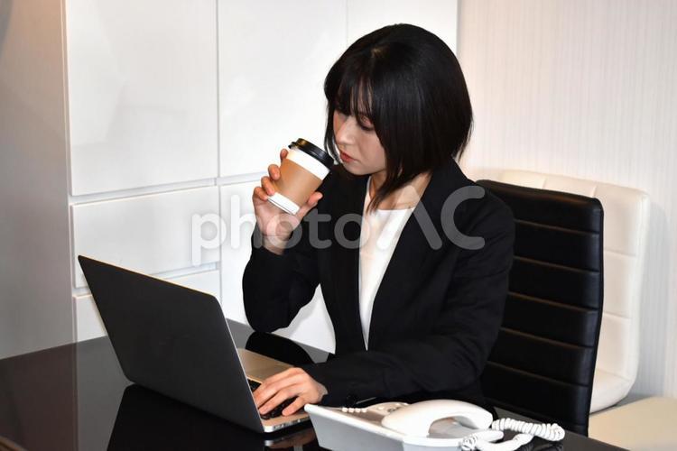 コーヒーを飲みながら仕事をする女性 ビジネス,女性,仕事の写真素材