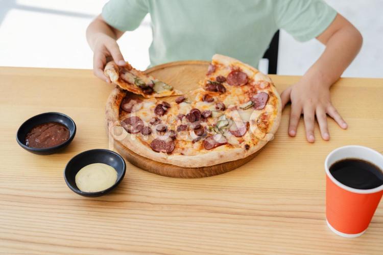 ピザを持ってこれから食べる人の手元 男の子,人物,ピザの写真素材
