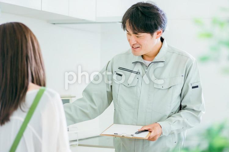 キッチンと作業着姿の男性（水道・笑顔） 水道屋,水漏れ,漏水の写真素材