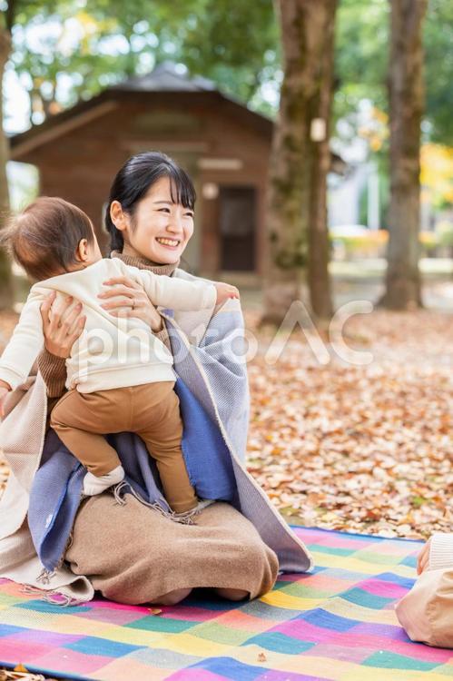 公園で赤ちゃんと抱っこしてママ友と話す女性 ママ友,話す,主婦の写真素材
