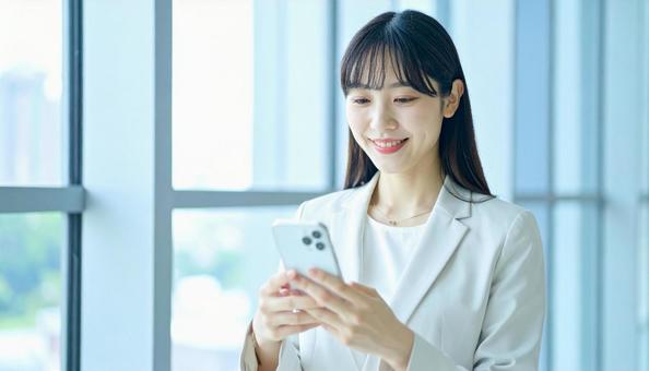 スマホを確認するビジネス女性 スマホを確認するビジネス女性の写真