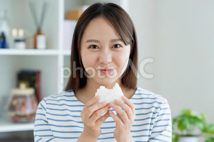 おにぎりを食べる若い女性 米,おにぎり,おむすびの写真素材
