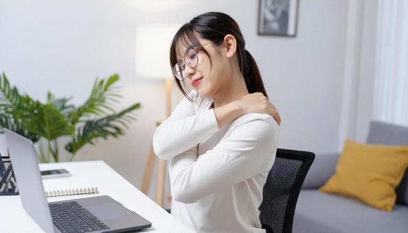 肩凝りに悩むテレワークの眼鏡の女性 肩凝りに悩むテレワークの眼鏡の女性の写真