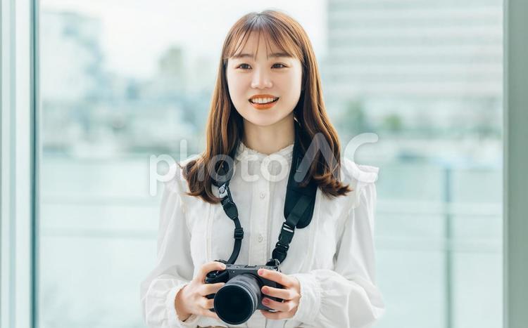 カメラを持つ笑顔の女性 女性,カメラ,カメラ女子の写真素材