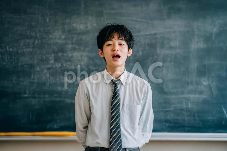 黒板の前で発表する男子生徒のイメージ 男子生徒,高校生,黒板の写真素材