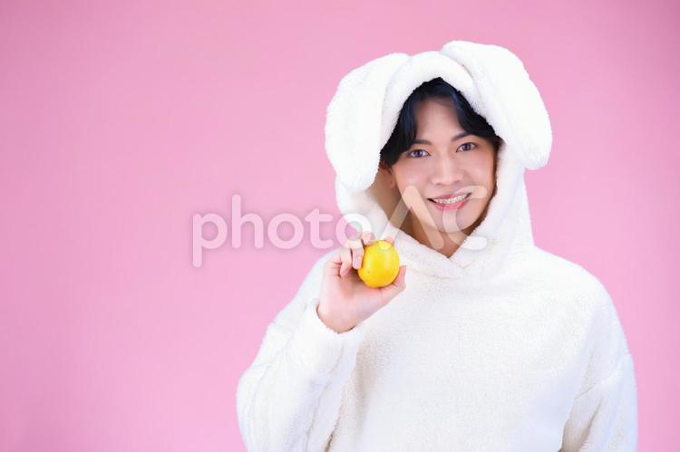 レモンを持ち笑顔のうさぎコスプレの男性 男性,レモン,果実の写真素材