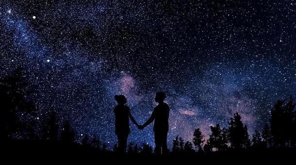 満天の星空の下で手をつなぐカップル・恋人 満天の星空の下で手をつなぐカップル・恋人の写真