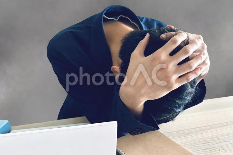 頭を抱える男性とモヤモヤ背景 悩み,不安,落ち込むの写真素材