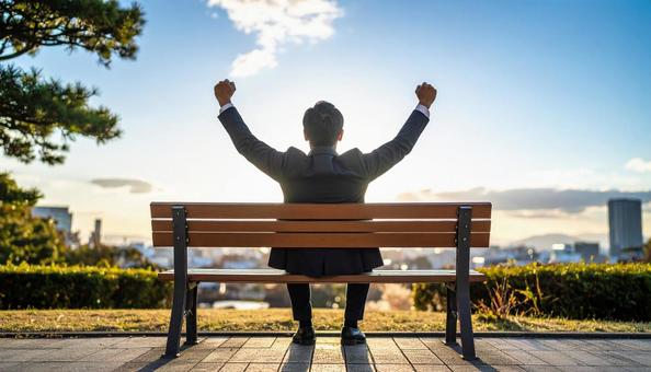 ベンチに座るビジネスマン(ストレッチ中) ベンチに座るビジネスマン(ストレッチ中)の写真