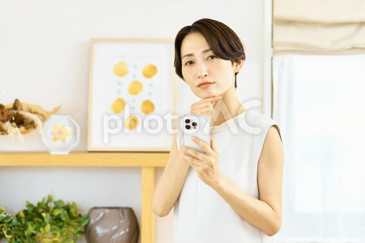 スマホを持つ女性　困る　考える スマホ,女性,主婦の写真素材