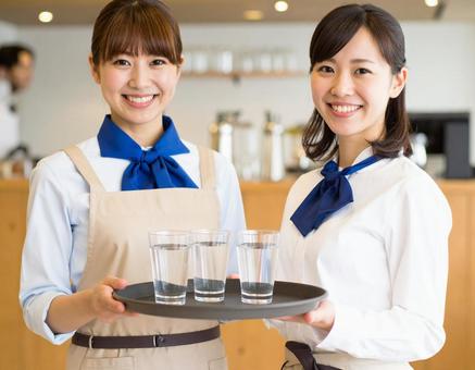 笑顔で迎えるカフェ店員の写真
