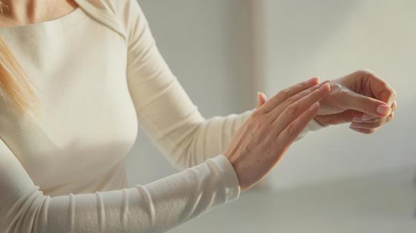 手に日焼け止めなどを塗っている女性の上半身 手に日焼け止めなどを塗っている女性の上半身の写真