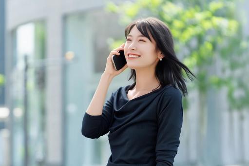 スマホで話す笑顔の女性・ビジネスウーマン 女性,スマホ,スマートフォンの写真素材