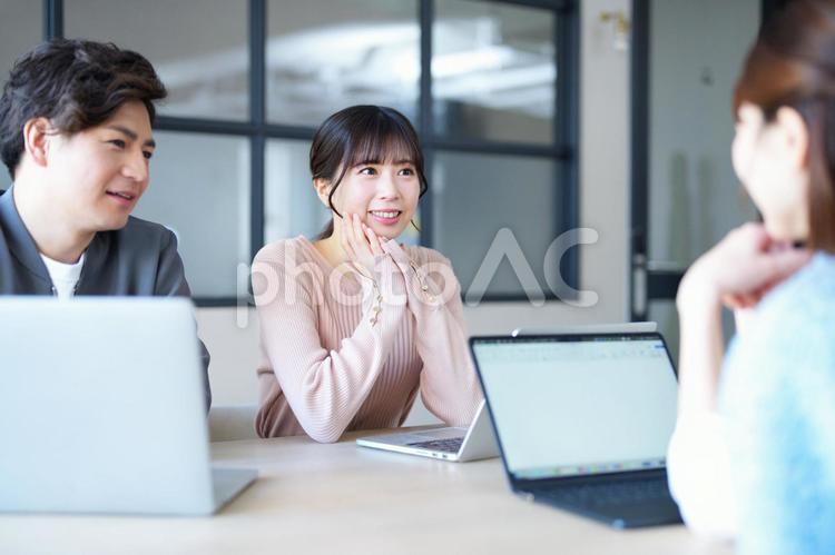 打ち合わせ中の笑顔の女性 男女,頬杖,女性の写真素材