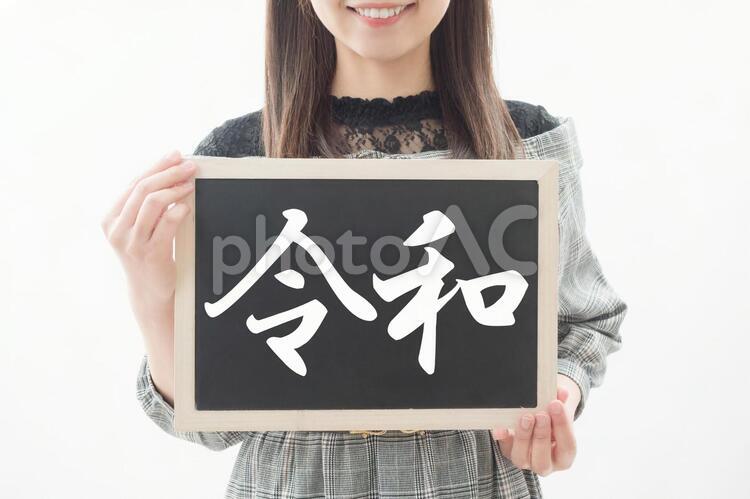 令和のボードを持ち微笑む女性のイメージ 令和,新年号,新元号の写真素材