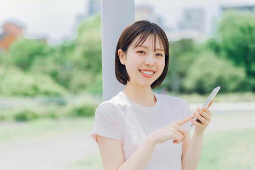 スマホを持つ若い女性 女性,スマホ,笑顔の写真素材