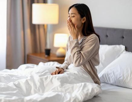 パジャマ姿であくびをする女性・朝の寝起き パジャマ姿であくびをする女性・朝の寝起きの写真