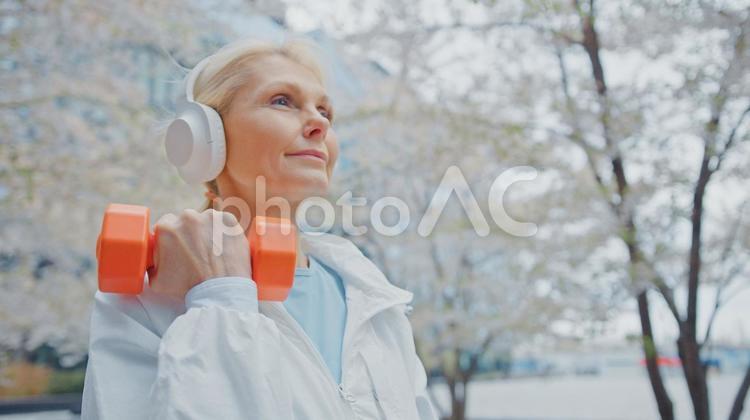 ヘッドフォンをして筋トレをするシニア女性 女性,人物,元気の写真素材