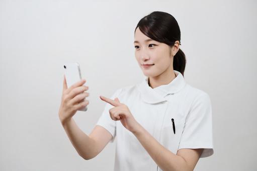 A woman in a white coat operating a smartphone A woman in a white coat operating a smartphone