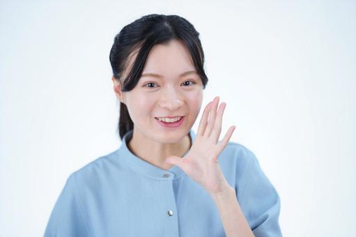 女性が人差し指を立てて笑顔を見せるの写真