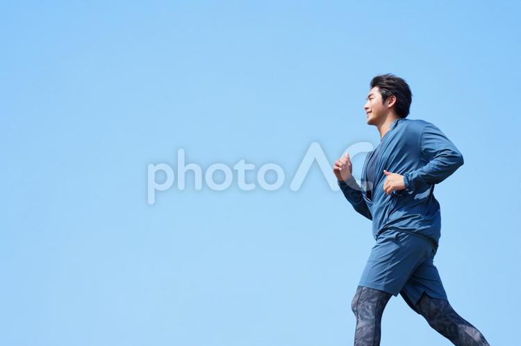 青空の下でジョギングする男性の横顔 男性,人物,横顔の写真素材