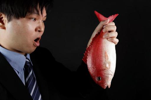 赤い魚を持つ男性 赤い魚を持つ男性 男性,魚,赤色の写真素材