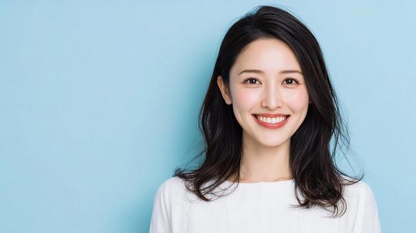 青背景の明るい笑顔の女性素材 青背景の明るい笑顔の女性素材の写真