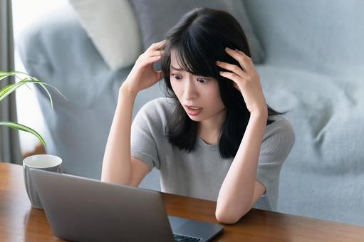 パソコンを使いながら困る女性 パソコンを使いながら困る女性 女性,困る,ショックの写真素材