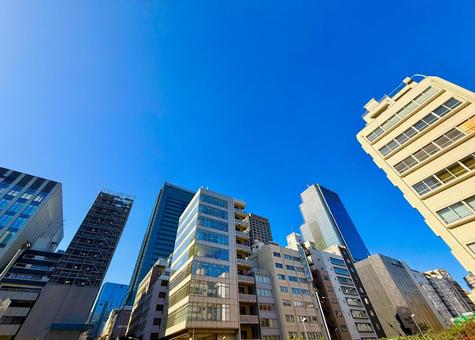 見上げる都心の高層ビル群とブルースカイ 見上げる都心の高層ビル群とブルースカイの写真