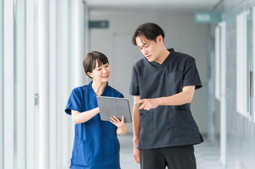 病院の通路で話す医者・医師・看護師の男女 医師,医者,電子カルテの写真素材