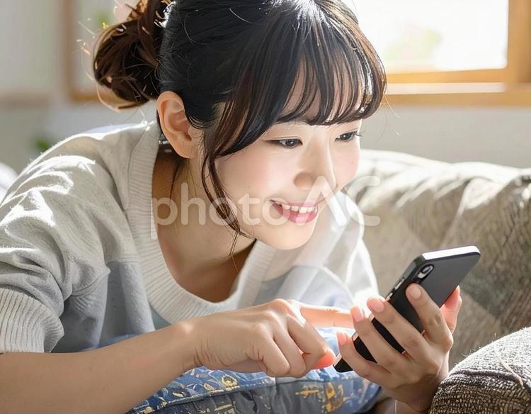 ソファでスマホを見る女性9 スマートフォン,スマホ,女性の写真素材
