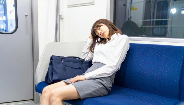 疲れて電車で熟睡している女性の社会人 疲れて電車で熟睡している女性の社会人の写真