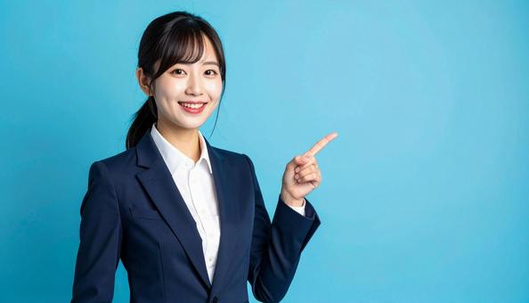 笑顔で指差すビジネスウーマンの写真