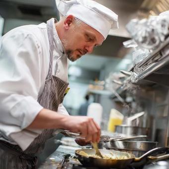 レストランの厨房で料理をするプロのシェフの写真