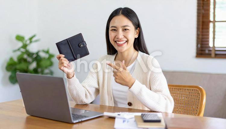 財布を指差すパソコンの前の女性 ネットバンキング,オンライン証券,ノートパソコンの写真素材