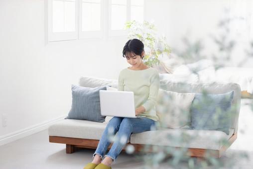 部屋でパソコンを使う女性 部屋でパソコンを使う女性 女性,ノートパソコン,パソコンの写真素材