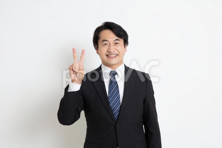 笑顔で指を2本立てている中年のサラリーマン男性 中年,上司,会社員の写真素材