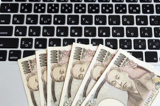 パソコンと紙幣のイメージ パソコンと紙幣のイメージ パソコン,紙幣,お金の写真素材