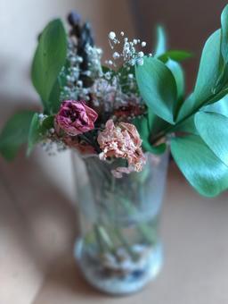 ガラス越しの花瓶にはいった枯れゆくブーケ ガラス越しの花瓶にはいった枯れゆくブーケの写真