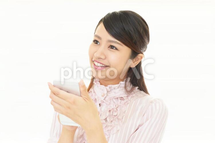 スマートフォンを持つ笑顔の女性 女性,スマートフォン,女の写真素材