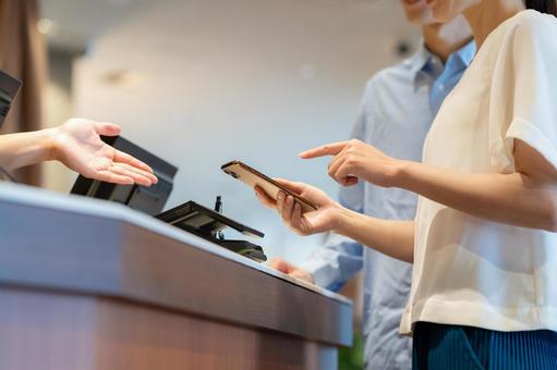 ショッピングをしてモバイル決済をする女性 モバイル決済,ショッピング,買い物の写真素材