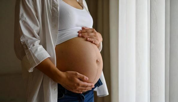 白いシャツを着た日本人妊婦の臨月のお腹 白いシャツを着た日本人妊婦の臨月のお腹の写真
