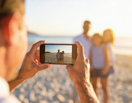 スマートフォンで撮影をする男性 スマートフォンで撮影をする男性の写真