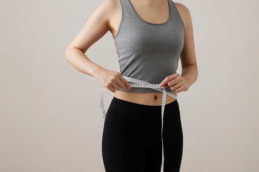 ウエストを測る女性の手元 ウエストを測る女性の手元の写真