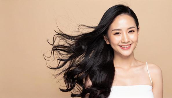 髪がなびいて笑顔の若い女性の写真